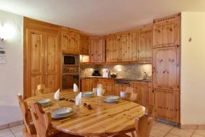 una cocina de madera con mesa y sillas de madera en Apartment Batteuse en Grimentz