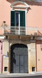 un edificio con una grande porta e un balcone di B&B Palazzo Rochira a Castellaneta
