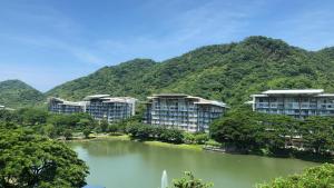 um grupo de edifícios de apartamentos ao lado de um lago em Pico de Loro 2BR Vacation Flat em Nasugbu