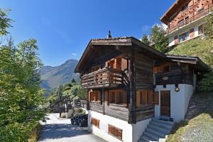una pequeña casa de madera con escaleras en las montañas en Chalet Diana, en Grimentz