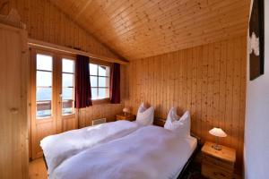 a bedroom with a white bed in a wooden room at Chalet Diana in Grimentz