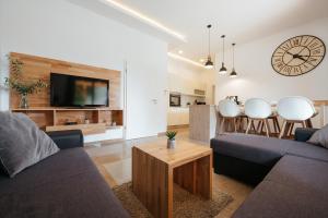 a living room with a couch and a tv and a table at Villa Privlaka in Privlaka