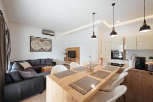 a kitchen and living room with a wooden table and chairs at Villa Privlaka in Privlaka