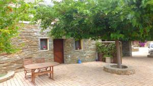 a wooden bench sitting in front of a stone building at Anastasia Luxury Villas in Gavrio