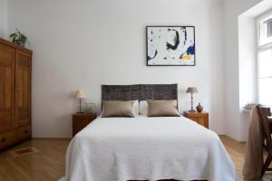 um quarto com uma cama com uma colcha branca em Apartment Jasmin em Zagreb
