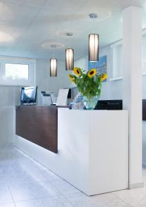 a lobby with a counter with a vase of flowers on it at Residence Appartements in Zurich