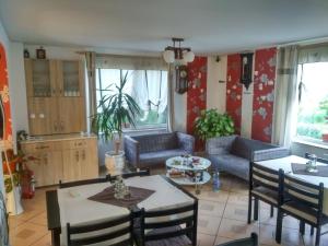 a living room with a table and chairs and a couch at Perla Neagră Lotus Spa in Câineni-Băi
