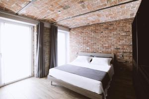 een slaapkamer met een bakstenen muur en een bed bij Villa Barbero Alba in Mango