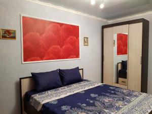 スタールイ・オスコルにあるКвартира на Королеваのベッドルーム1室(ベッド1台付)が備わります。壁には絵画が飾られています。