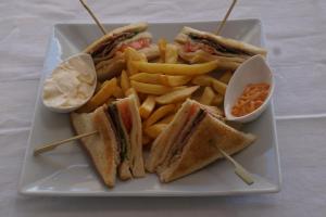 een wit bord met een broodje en frietjes bij Cavos Fokidos in Chiliadou