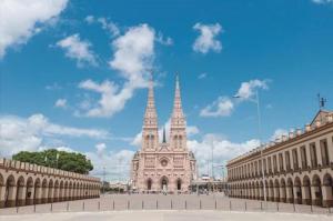 a large building with two towers in a city at Casa centrica Luján in Luján