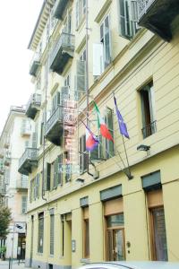 trzy flagi na boku budynku w obiekcie Taverna Dantesca w Turynie