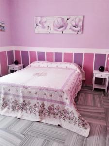 um quarto rosa com uma cama com uma parede rosa em Hotel Serenella em Turim