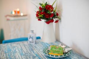 a table with a plate of food and a vase with flowers at Versomare in Polignano a Mare