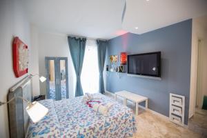 a bedroom with a bed and a tv on a wall at Versomare in Polignano a Mare