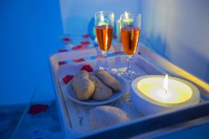 a tray with two glasses of wine and cookies and candles at Versomare in Polignano a Mare