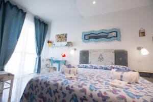 a bedroom with a bed with a comforter on it at Versomare in Polignano a Mare