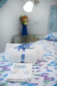 a pile of towels with a blue bow on a bed at Versomare in Polignano a Mare