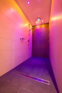 グロースアルルにあるHotel Landhaus Neumayrの紫色のバスルーム(紫色の照明付きシャワー付)