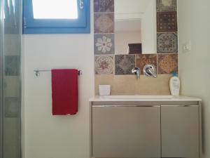 bagno con lavandino e asciugamano rosso di Casa Lulù a Presicce