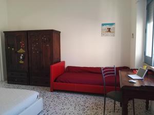 sala de estar con sofá rojo y mesa en Casa Lulù, en Presicce