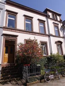 une maison blanche avec une clôture devant elle dans l'établissement Ferienwohnung am Schloss, à Karlsruhe