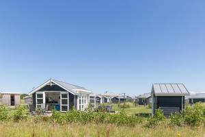 eine Reihe von Häusern auf einem Grasfeld in der Unterkunft Duinpark Westerschouwen in Burgh Haamstede