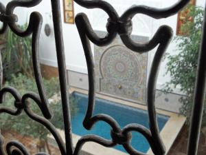 an iron gate with a view of a pool at Riad Attarine in Fez