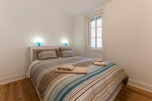 a bedroom with a bed with two towels on it at Apartment in Center of Lisbon in Lisbon