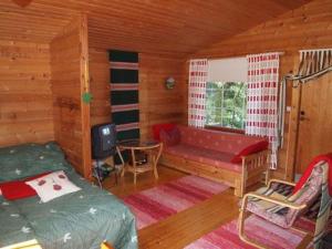 um quarto com uma cama e uma televisão numa cabana em Holiday Home Raanumökki 4 by Interhome em Lampsijärvi