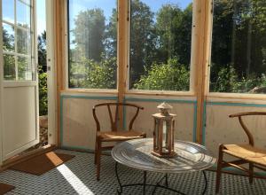 a room with two chairs and a glass table in front of windows at Lille Carlsson Studio in Broby