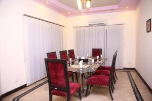 une salle à manger avec une table et des chaises rouges dans l'établissement Safari Club 2 Bahria Town, à Rawalpindi
