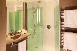 a bathroom with a glass shower and a sink at Hôtel & SPA Oceania L'Univers Tours in Tours +50 photos