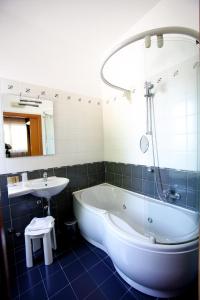 La salle de bains est pourvue d'une baignoire, d'un lavabo et d'une baignoire. dans l'établissement Hotel De La Ville, à Bereguardo