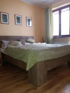 a bedroom with a large bed with a green comforter at Dom Gościnny "Pod Siódemką" in Szklarska Poręba