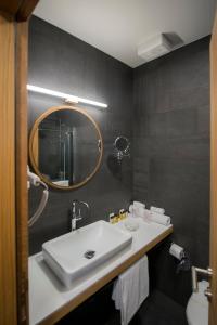 a bathroom with a white sink and a mirror at Hotel Sana in Sarajevo