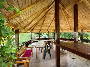 a large wooden pavilion with a table and chairs at Pensiunea Bobu in Izvoru Muntelui