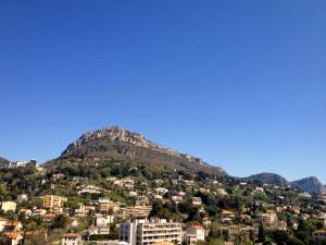 Eine Stadt auf einem Hügel mit einem Berg im Hintergrund in der Unterkunft Logis Hotel Diana in Vence