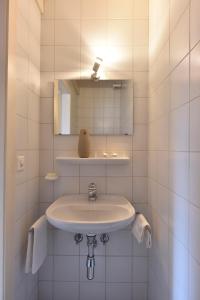 a white bathroom with a sink and a mirror at Chalet Mousseron in Grimentz