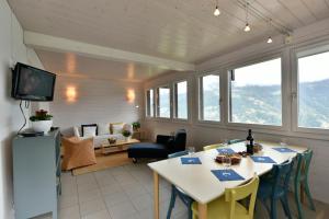 Chalet Mousseron في غريمينتز: غرفة معيشة مع طاولات وكراسي وتلفزيون