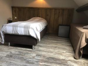 um quarto com 2 camas e piso em madeira em Bed & Breakfast de Bimd Hoeve em De Bus