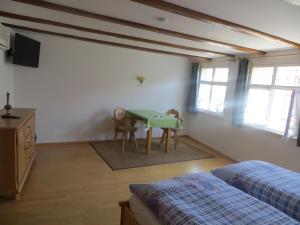 1 dormitorio con mesa, cama y ventanas en Ferienwohnungen Greitmann, en Meersburg