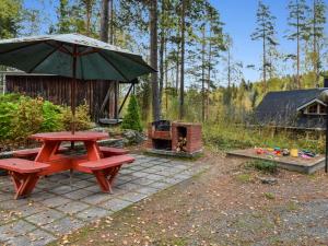einen Picknicktisch mit Sonnenschirm und Grill in der Unterkunft Holiday Home Mykkylä by Interhome in Niemi