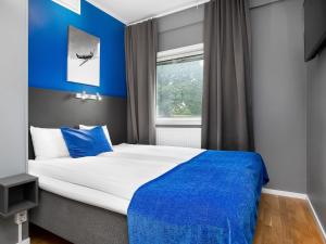 a bedroom with a white bed and blue curtains at Connect Hotel Arlanda in Arlanda