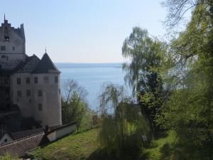 um castelo numa colina ao lado de um corpo de água em Ferienwohnungen Greitmann em Meersburg