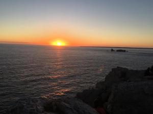 a sunset over the ocean with the sun setting at L améthystes in Crozon