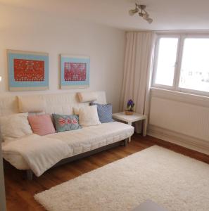 a living room with a white couch and a window at Ferienwohnung am Schloss in Karlsruhe +9 photos