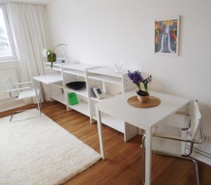 Habitación con escritorio blanco y mesa blanca. en Ferienwohnung am Schloss en Karlsruhe