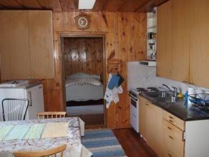 uma cozinha com geladeira e fogão forno superior em Holiday Home Raanumaja ii by Interhome em Lampsijärvi