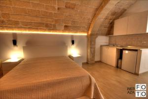a bedroom with a large bed in a brick wall at Suite Stone Luxury in Monopoli +4 photos